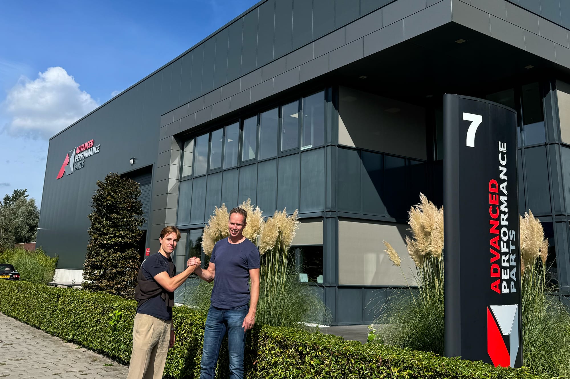 Moos van Momentum en Egbert van APP Europe geven elkaar een hand voor het pand van APP